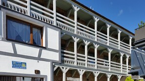Un edificio a più piani con facciata bianca e balconi.
