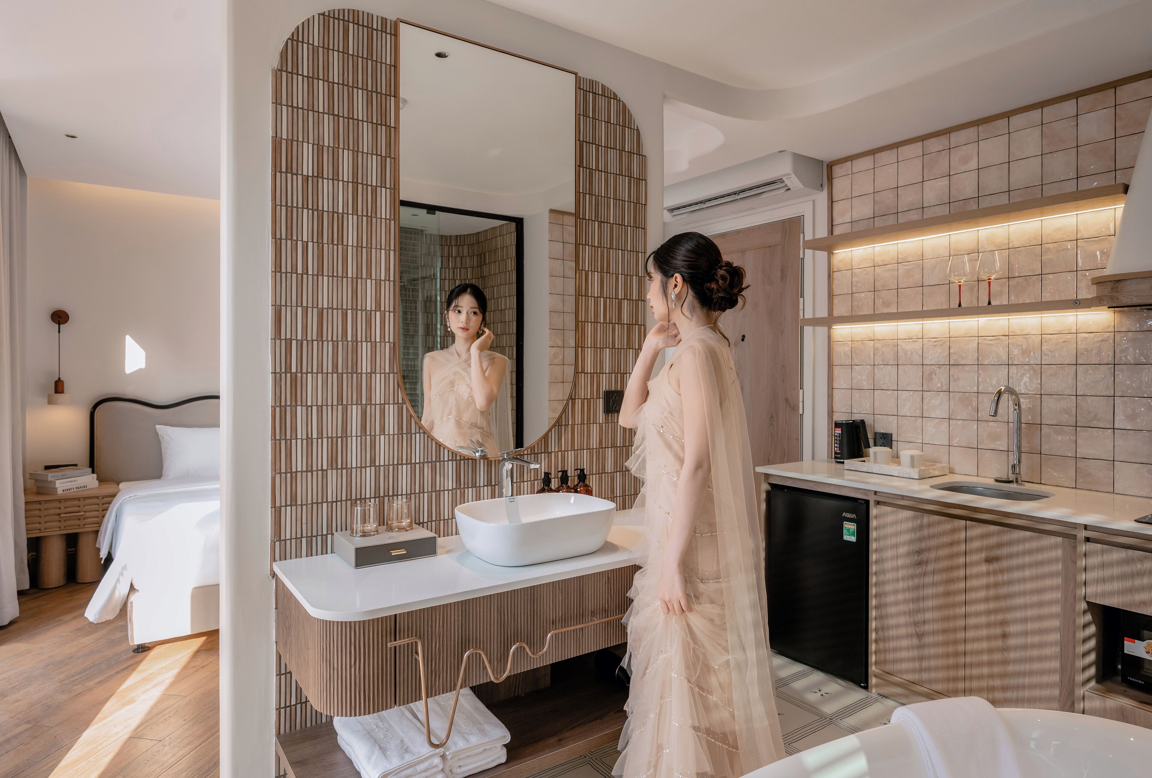 A modern hotel bathroom with a large mirror, a sink, and a shower area.