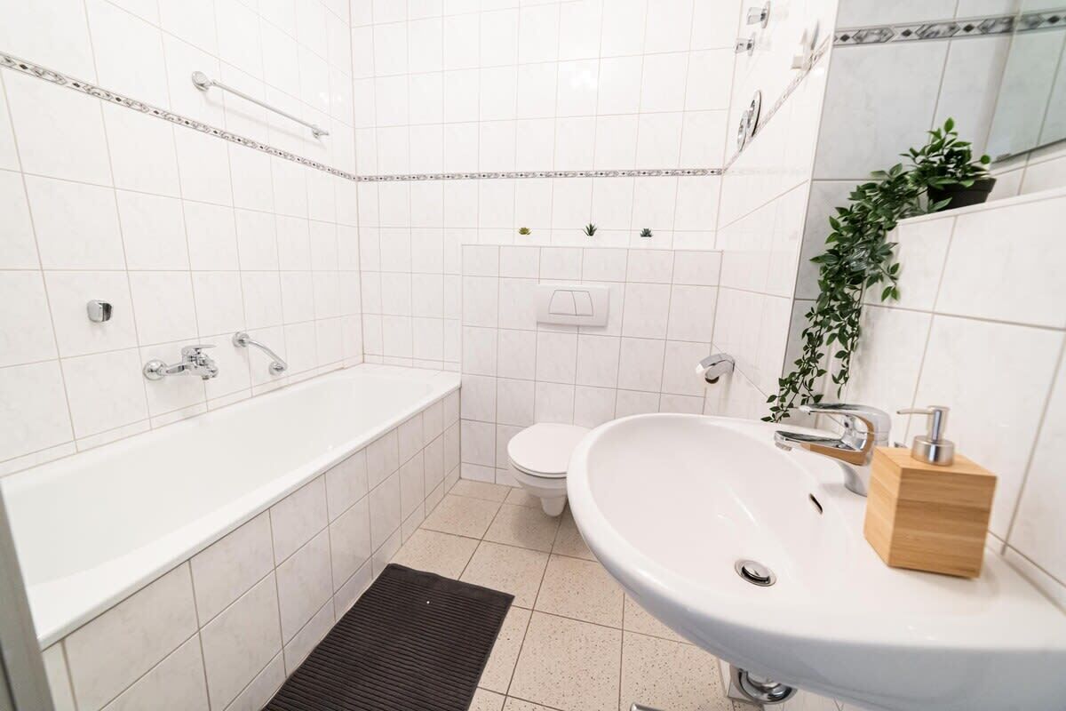 Un baño moderno con una bañera blanca, un lavabo y un inodoro.