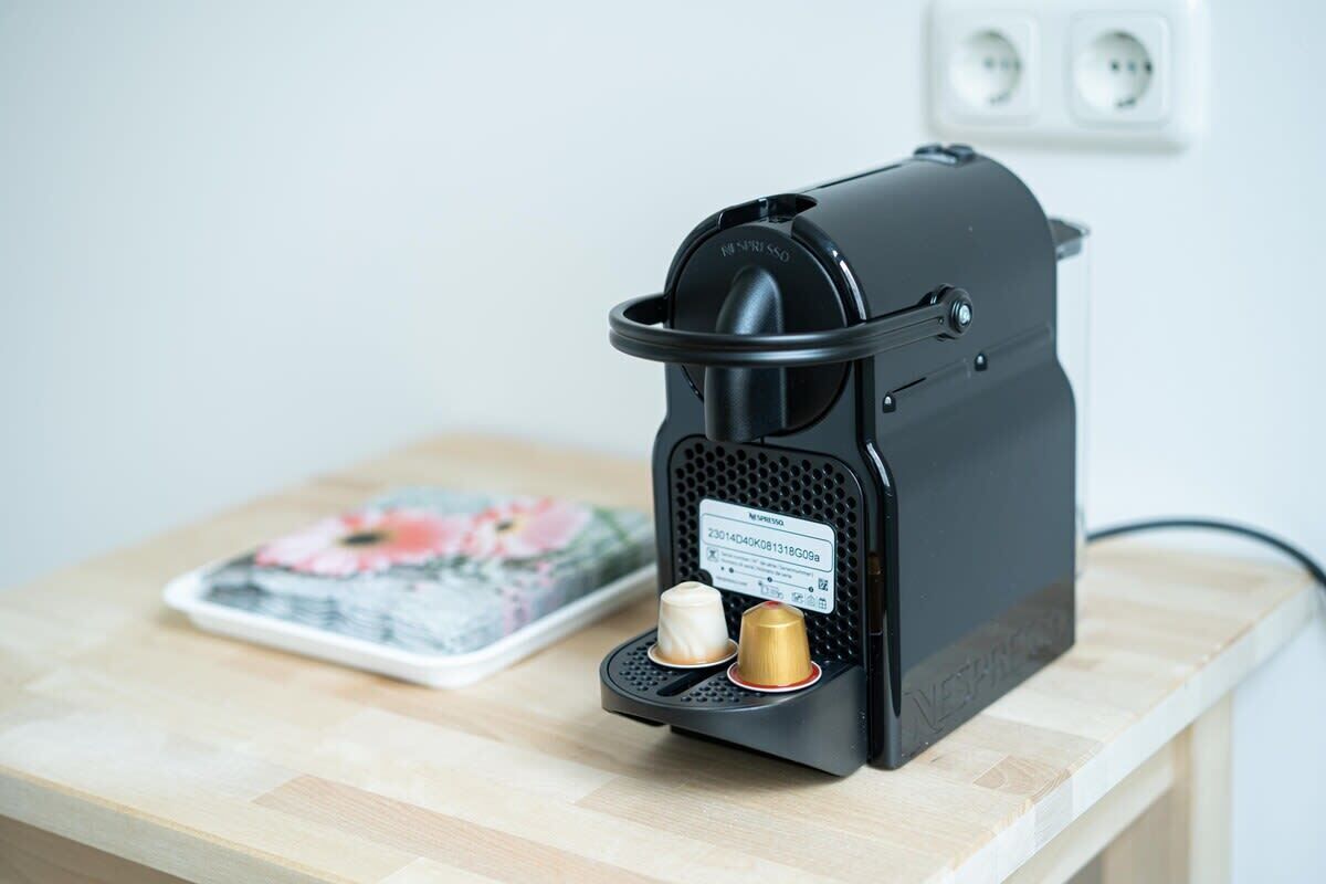 A coffee machine with two coffee pods on a wooden table.