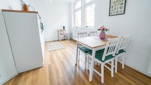 A compact kitchen with white cabinetry, a wooden countertop, and a window providing natural light. - FullHouse | Magdeburg | L10-2 | FamilienApartment (Magdeburg)