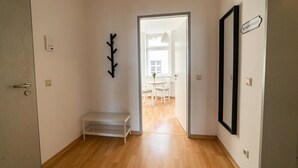 A hallway with a bench, a coat rack, and a sign that reads "MY HAPPINESS PLACE".