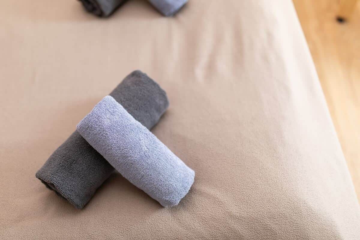 Hierontapöytä, jonka päällä on kaksi rullalle taitettua pyyhettä.