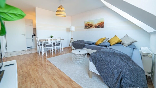Ein modernes Loft mit Essbereich, einer Sofagarnitur und einem großen Fenster für natürliches Licht.