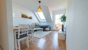 Eine moderne Loftswohnung mit Essbereich, einer Couch und einem großen Fenster.