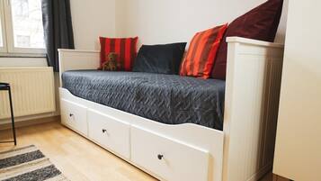 A bedroom with a bed, a teddy bear, and a radiator.