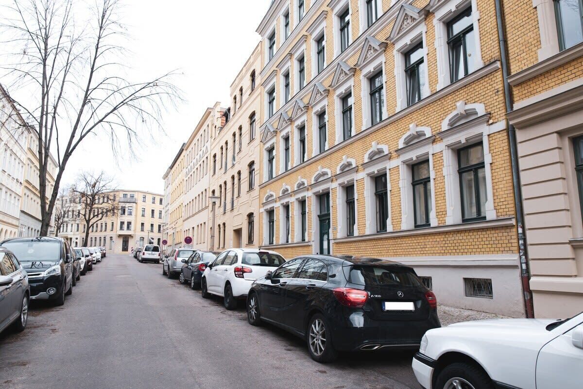 A street lined with parked cars and buildings with classic architecture.