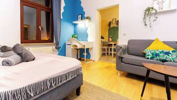 A bedroom with a bed, a desk, and a sofa.