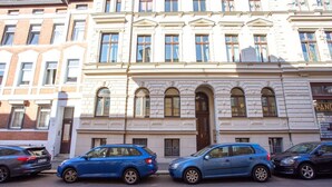 Un immeuble à plusieurs étages de style architectural classique, caractérisé par des fenêtres en arc et une entrée centrale.