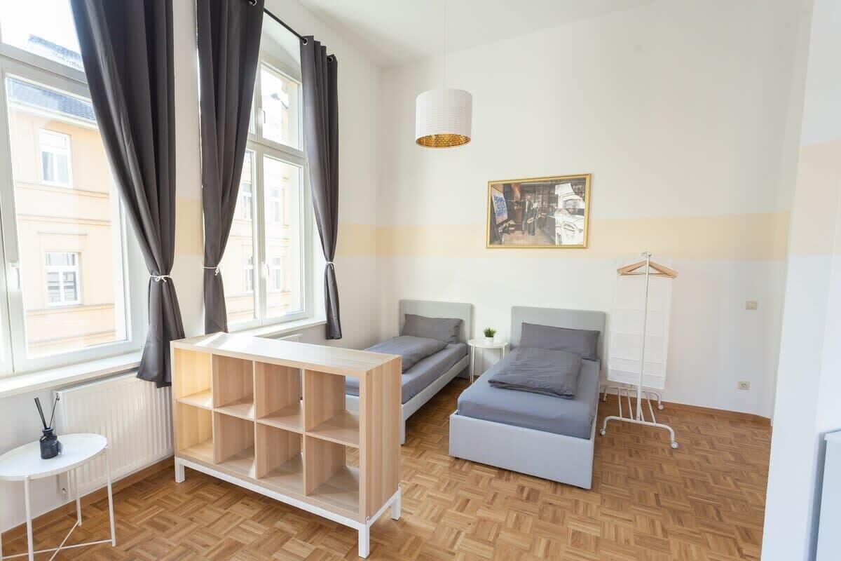 Un dormitorio moderno con cama, escritorio y lámpara de pie.