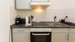 A kitchen with a stove, oven, sink, and cabinets. - FullHouse | Halle | R6 Amsterdam (Halle (Saale))