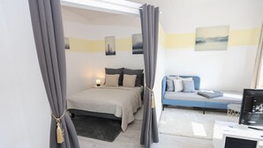 A modern bedroom with a bed, bedside table, and a desk with a computer. - FullHouse | Chemnitz | M45-1 | Studio (Chemnitz)