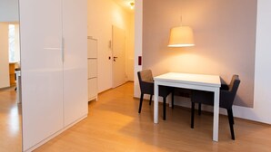 Una cucina moderna con mobili bianchi, un piano di lavoro bianco e un lampadario.