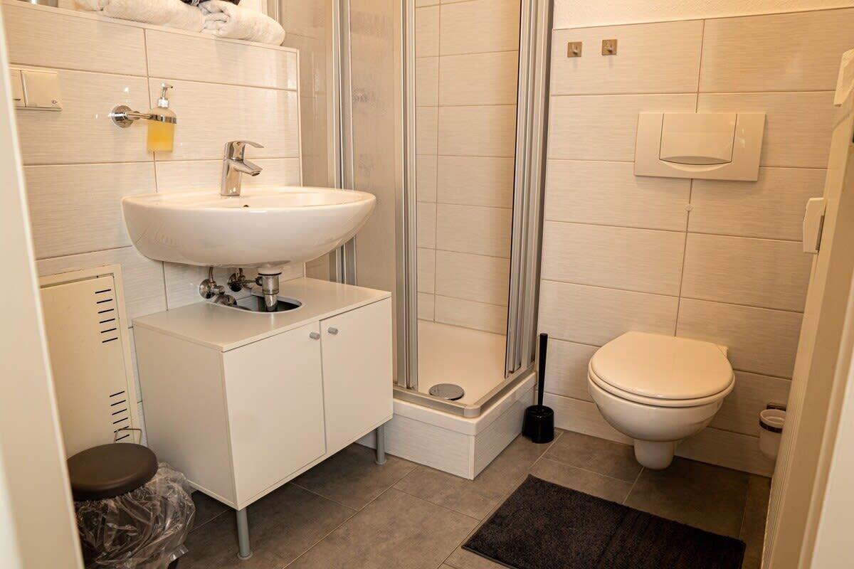 Ein Badezimmer mit Waschbecken, Toilette und Dusche.