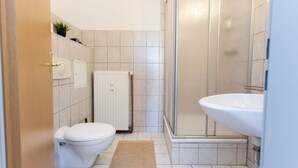 Un baño moderno con inodoro, ducha y lavabo.