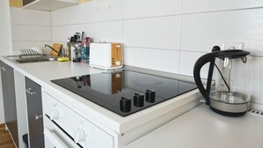 A modern kitchen with a built-in stove, a coffee maker, and a knife block. - FullHouse | Halle | T28 Elephant Apt. (Halle (Saale))