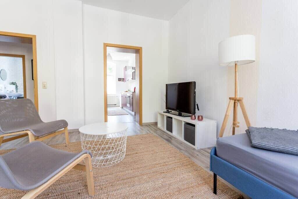 Een moderne hotelkamer met een televisie, zithoek en een lamp.