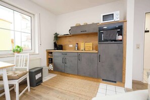 Een koelkast, een oven, een kookplaat, een koffiezetapparaat/waterkoker