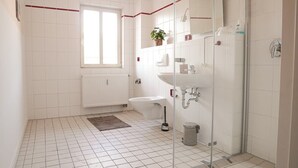 Une salle de bain moderne avec une douche à parois de verre, des toilettes, un lavabo et une fenêtre.