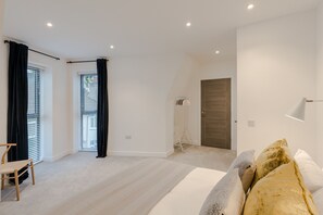A modern bedroom with a bed, a chair, a wardrobe, and a door. - Ladywell 2 bd Flat - Fast WiFi | Smart TV | Modern (London)