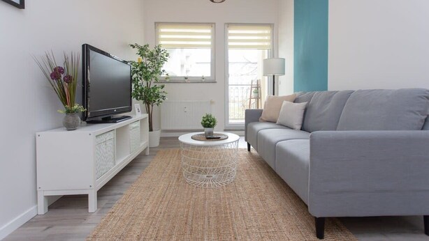 A modern living room with a grey sofa, a white entertainment unit, and a round coffee table. - FullHouse | Chemnitz | Rosenhof C8 | Zentrum (Chemnitz)