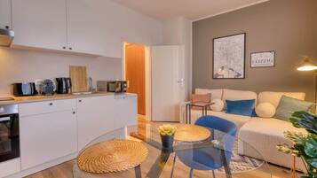 Un appartement moderne comprenant une cuisine, un coin repas et un salon.