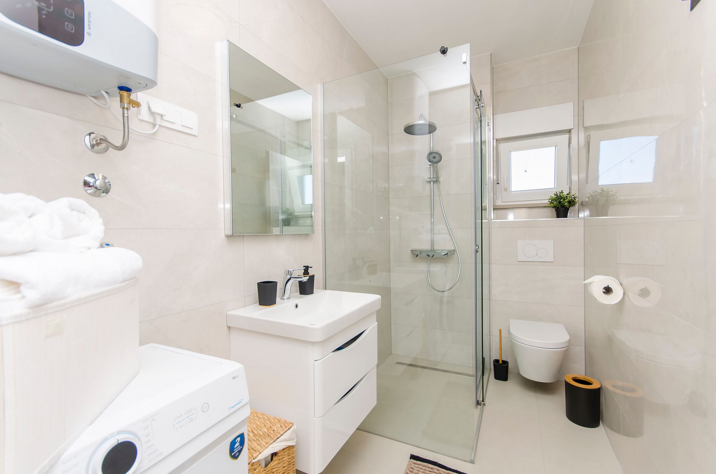 Une salle de bain moderne avec une douche à parois de verre, un lavabo blanc et des toilettes.