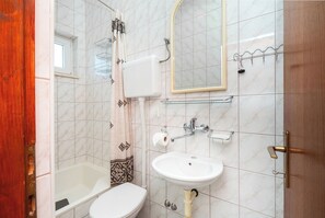Ein Badezimmer mit Toilette, Waschbecken und Badewanne.