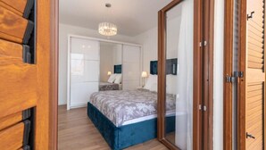 Un dormitorio con una cama grande, un armario y un espejo.