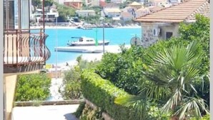 Un pueblo costero con un camino que lleva a un balcón con vistas a un puerto deportivo.