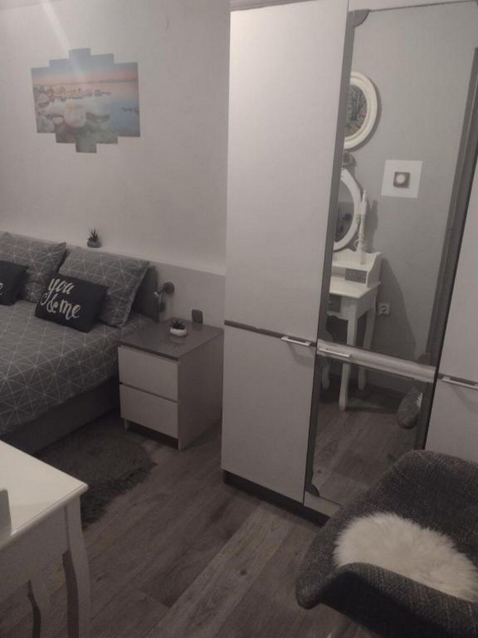 Un dormitorio con cama, mesita de noche y armario.