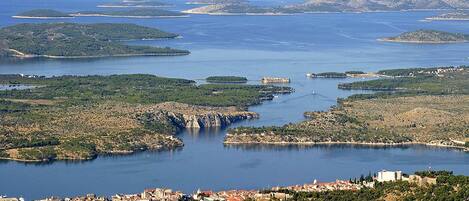 A coastal town with a marina, surrounded by hills and water bodies.