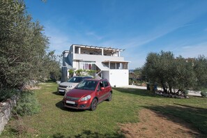 Una casa moderna de dos pisos con un coche estacionado en el jardín delantero.