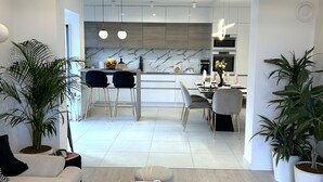 Ein modernes Wohnzimmer mit einer Couch, einem Couchtisch und Topfpflanzen.