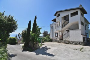 A two-story building with a balcony and a staircase. - Apartment Lokva (Lovran)