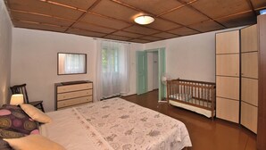 Un dormitorio con cama, cómoda y cuna.
