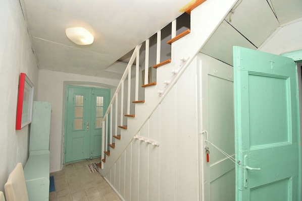 A staircase with white railings and wooden steps leading to a door. - Apartment Gaspar (Mali Losinj)