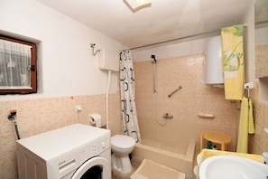A bathroom with a washing machine, toilet, shower, and bathtub. - Apartment Gaspar (Mali Losinj)