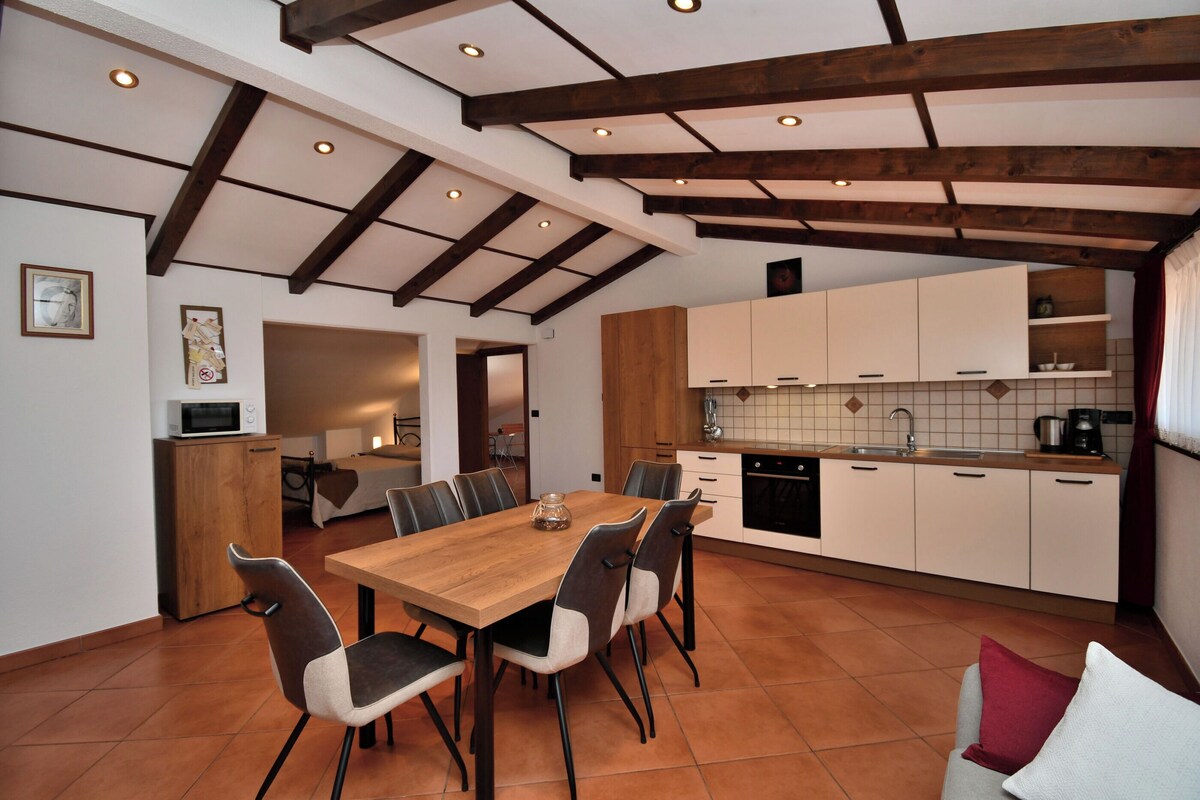 Una cocina moderna con armarios blancos, una mesa de comedor de madera y un salpicadero de azulejos.