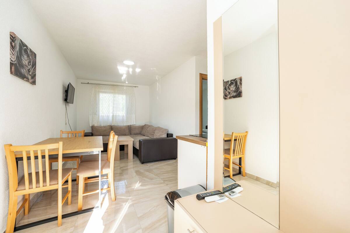 Een moderne woonkamer met een eettafel, bank en stoelen.