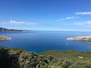 A coastal landscape with a clear view of the sea, hills, and a small island. - Apartments Rose (Mali Losinj)