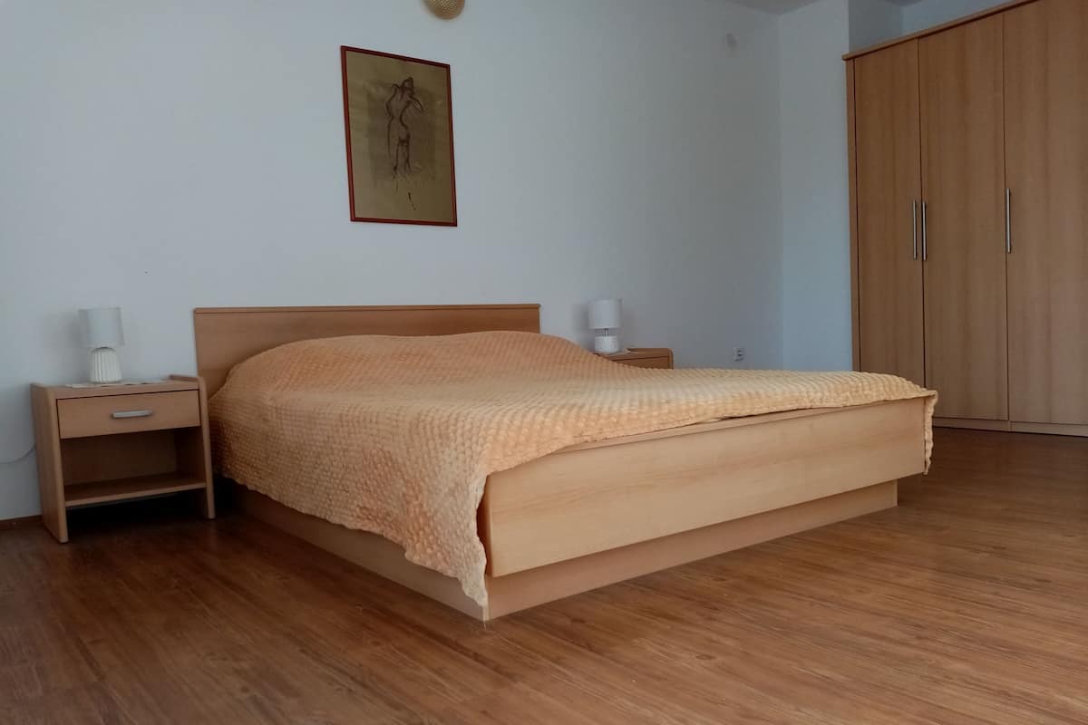 A bedroom with a wooden bed, nightstands, and a wardrobe.