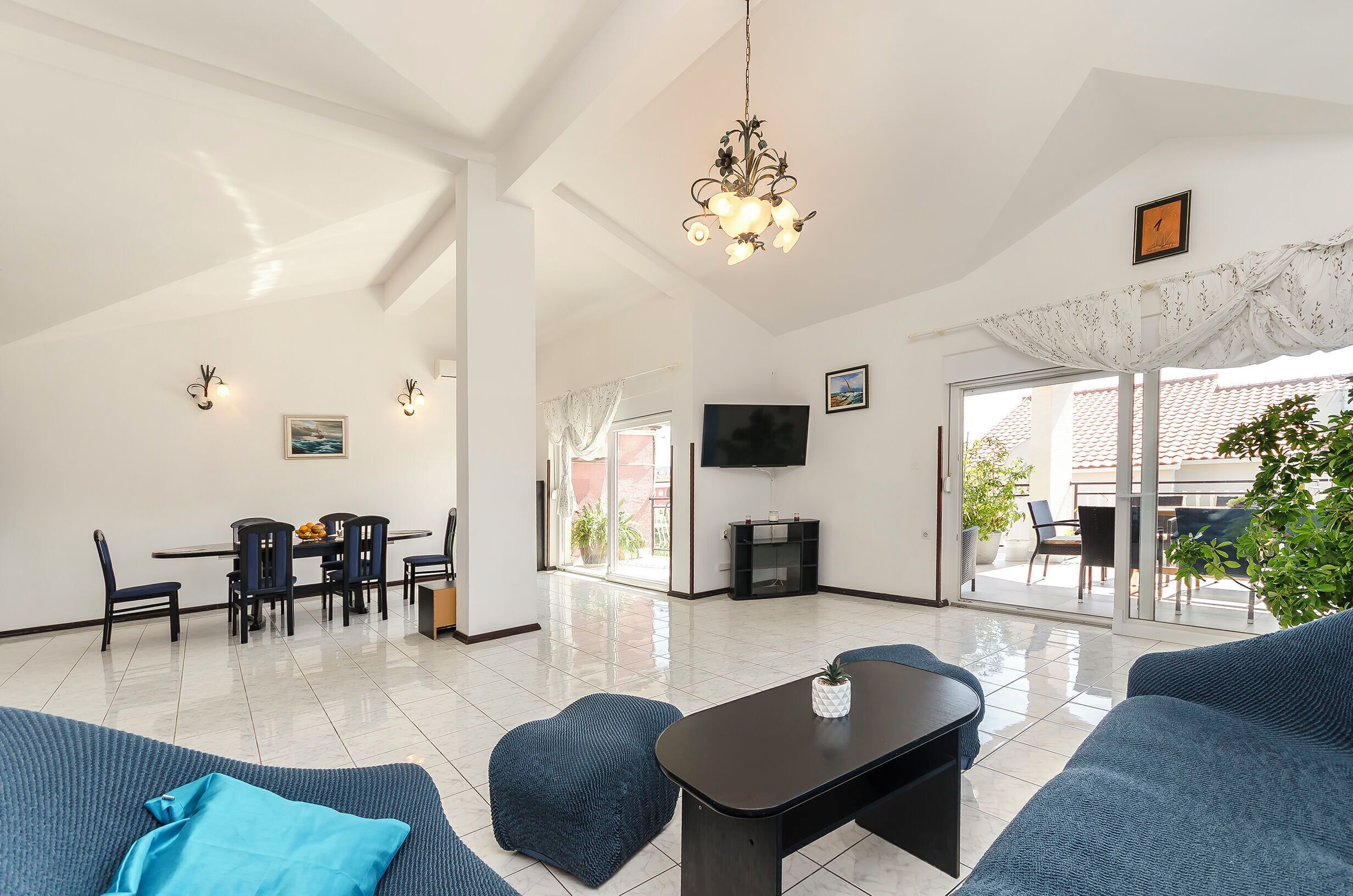 A spacious living area with a dining set, a TV, and a fireplace.