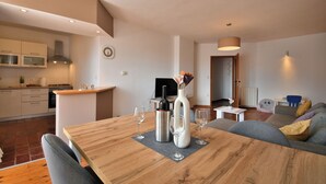 A modern living space with a dining table, kitchen, and seating area. - Apartment Honey Bee (Pula)