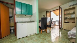 A compact kitchen with a refrigerator, a sink, and green cabinets. - Apartments Marinero (Pakostane)