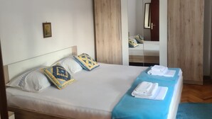 A bedroom with a bed, wooden wardrobe, and a mirror. - Apartment Cosy Terrace (Sibenik)