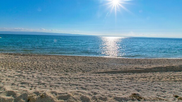 A beach with a clear sky and calm sea. - Apartment Beleca (Podstrana)