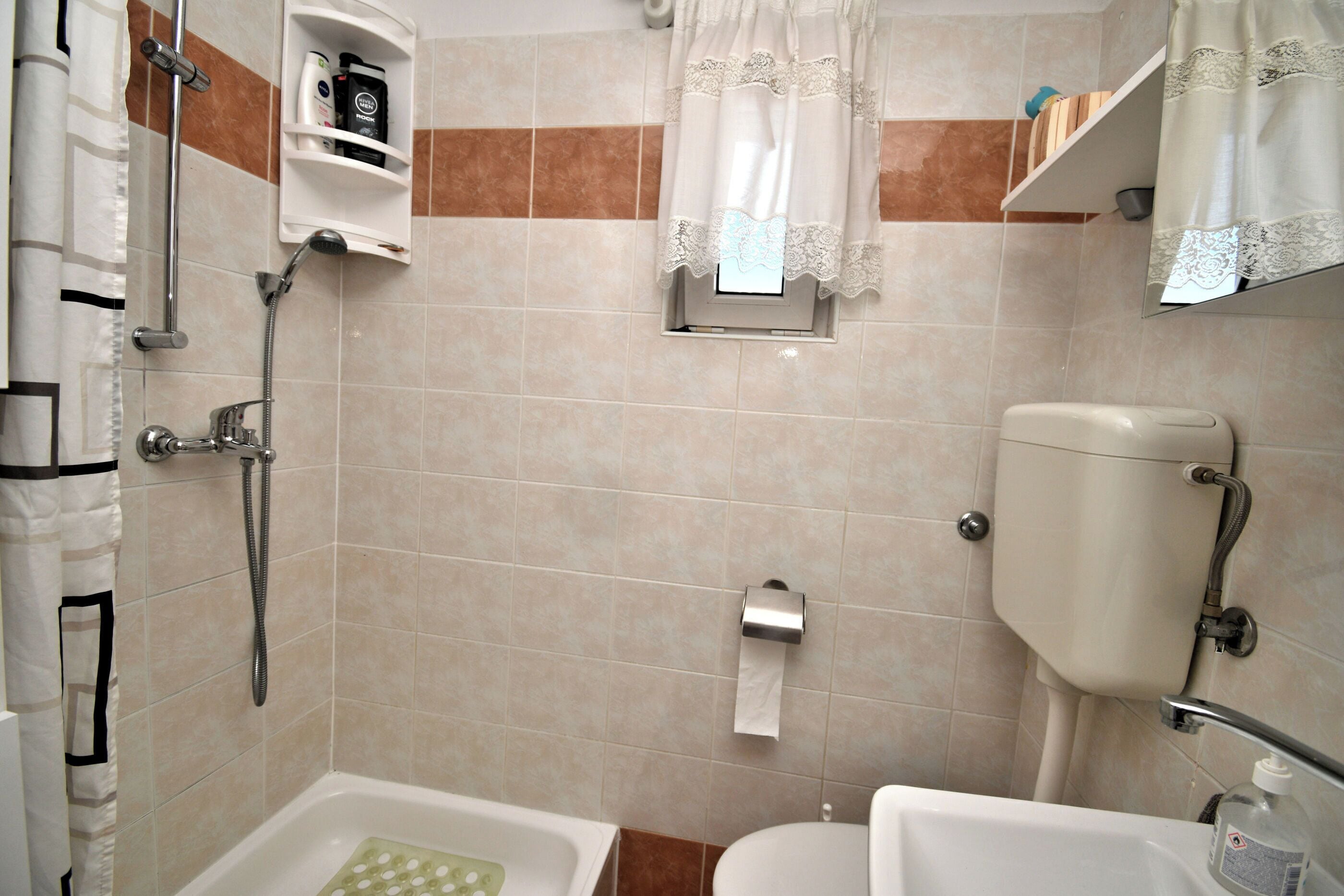 A bathroom with a shower, toilet, and sink.