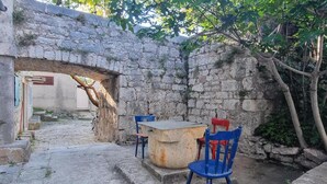 A stone wall with a narrow passageway leading to a door. - House Zlatni Otok (Sibenik)