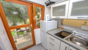 A compact kitchen with a built-in refrigerator, a sink, and a small countertop. - Apartment Mladen (Pakostane)